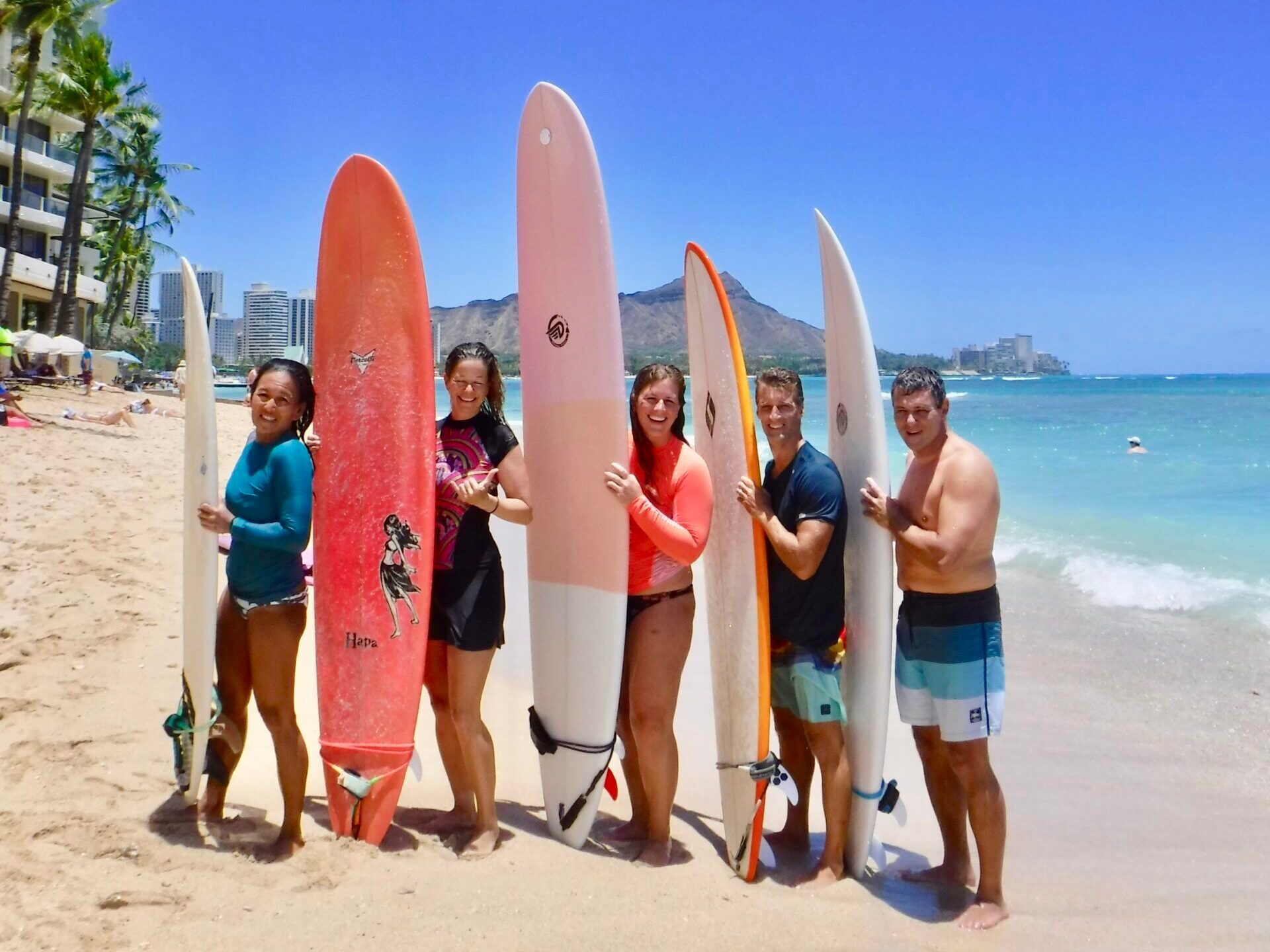 a group of people standing on a beach posing for the camera